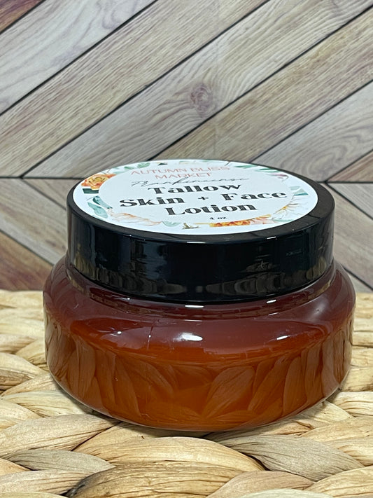 A jar of Tallow Skin + Face Lotion with a label that includes the brand name and product name, placed on a woven mat with a wooden background.