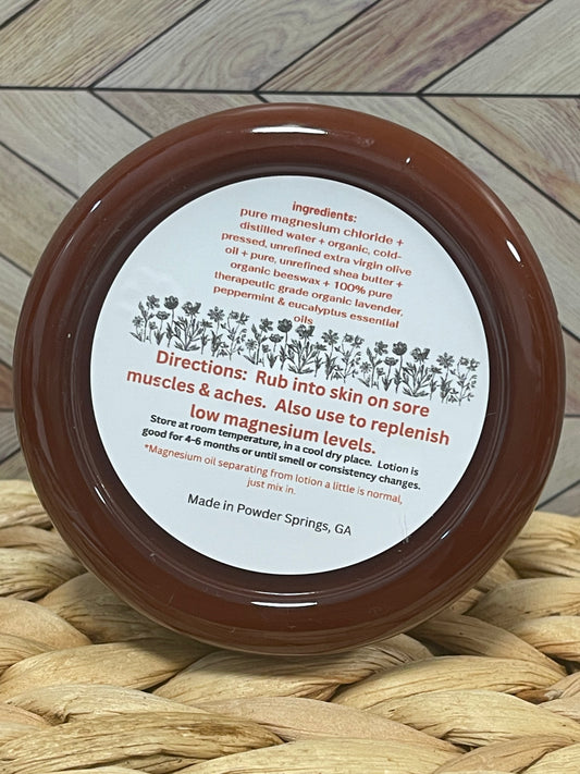 Jar of Magnesium Lotion showing the ingredients and directions placed on a woven mat with a wooden surface background.