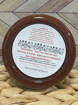 Jar of Magnesium Lotion showing the ingredients and directions placed on a woven mat with a wooden surface background.