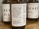 Bottles of beard oil with labels indicating ingredients with the product name and cedar spice scent.