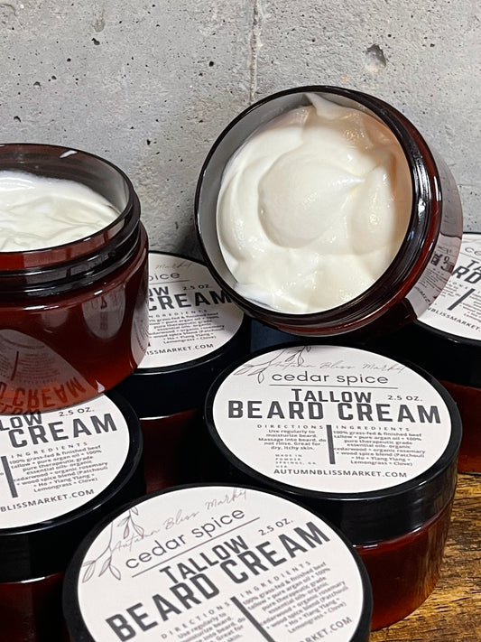 Multiple Tallow Beard Cream products with cedar spice scent on a wooden surface with ash background showing the content of the product.