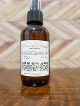 Bottle of Magnesium Oil Spray placed on a wooden surface.