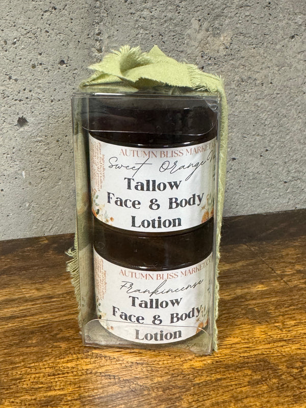 Two tallow face and body lotions in glass jars with labels on a wooden surface.