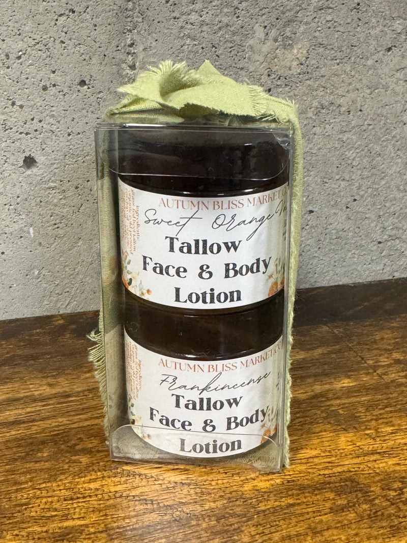 Two tallow face and body lotions in glass jars with labels on a wooden surface.